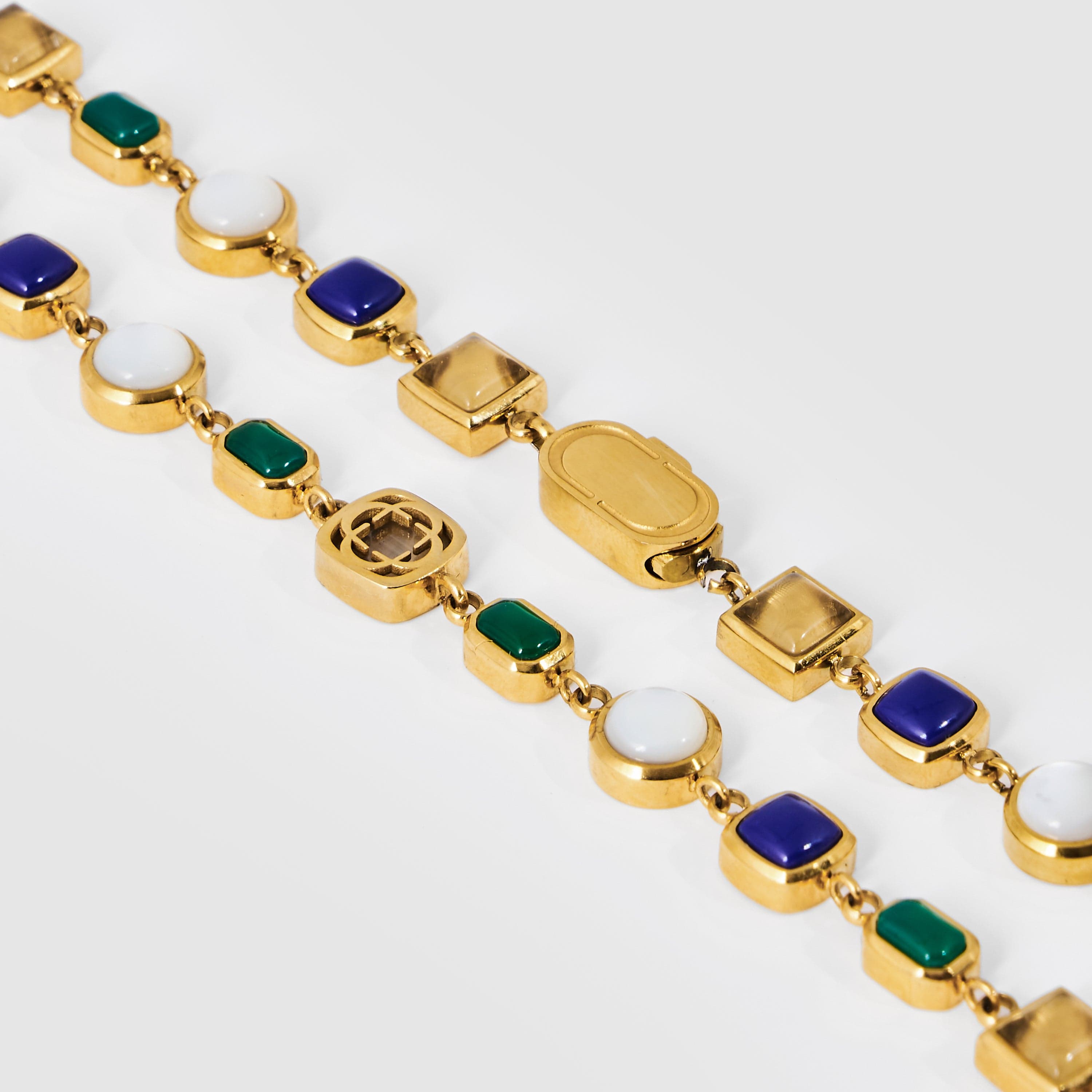 Gold necklace with colored gemstones on a white background